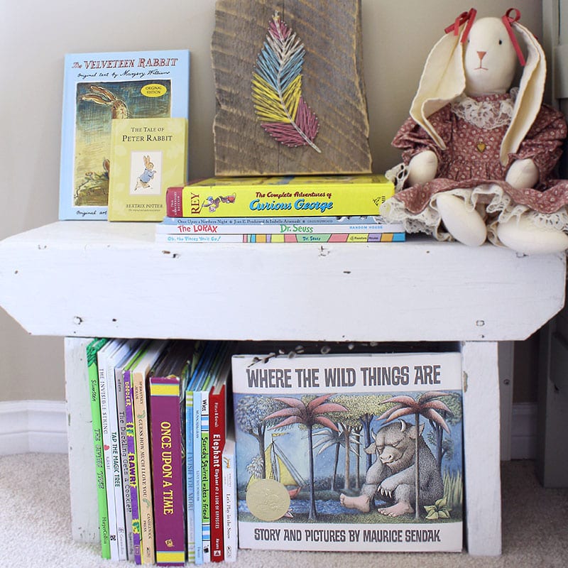 Small home library using a bench lined with children's picture books.