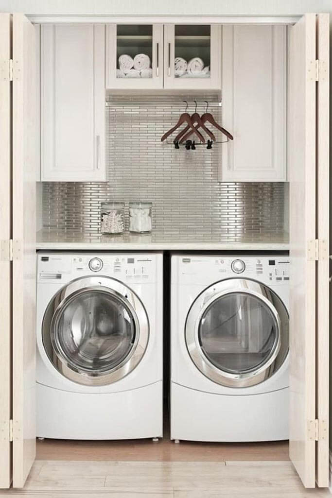 A closet laundry room with a white washer and dryer.