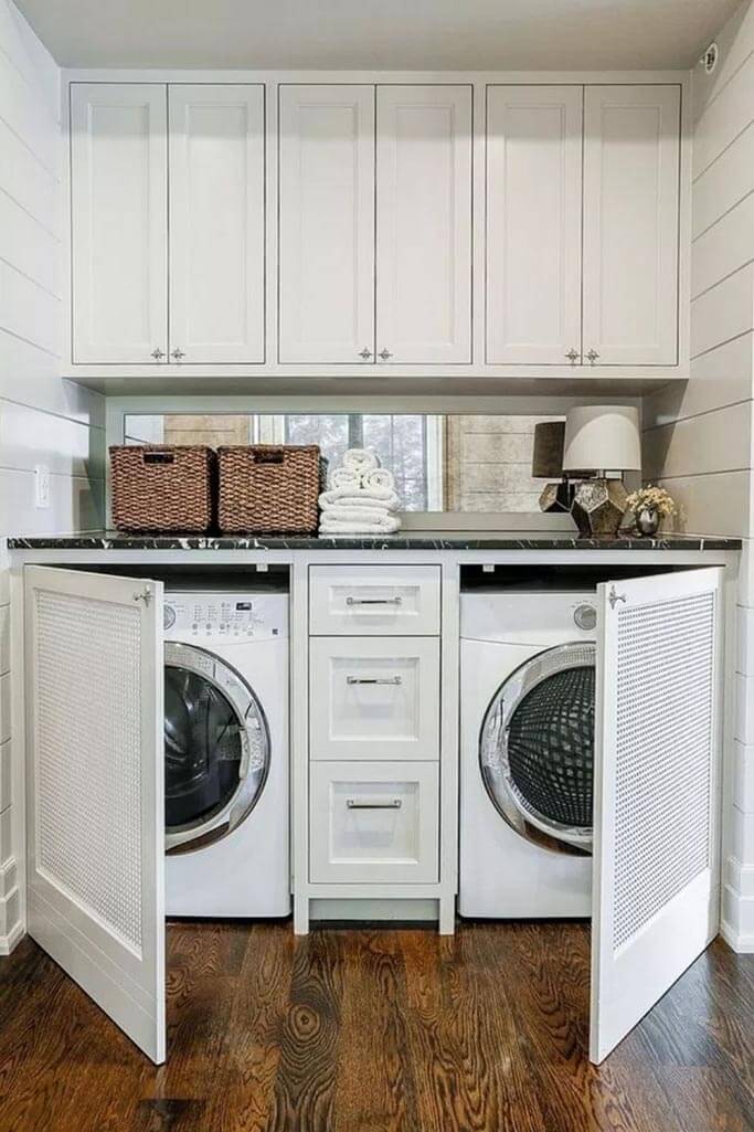 A laundry room with cream cabinets and a white washer and dryer.