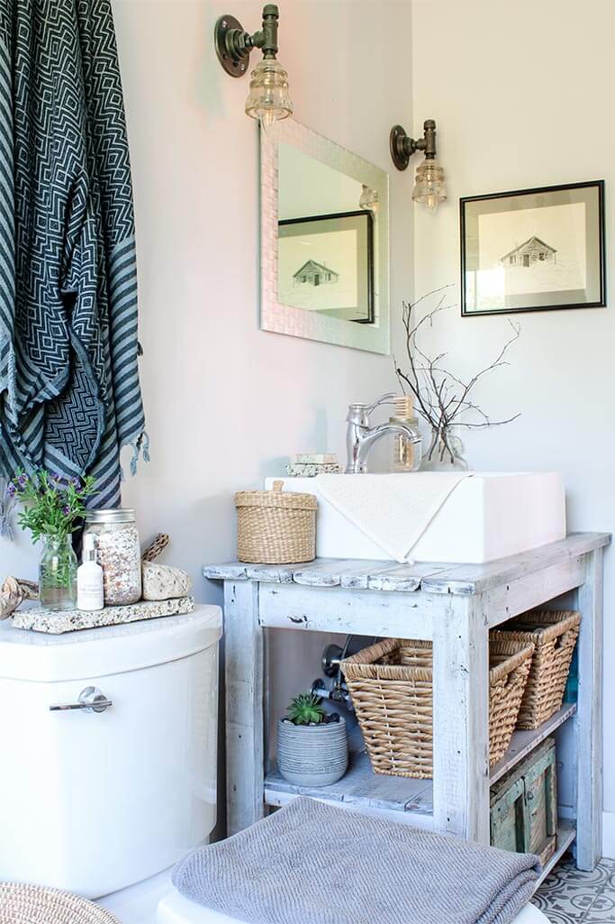A bright bathroom with with vintage art and woven baskets.