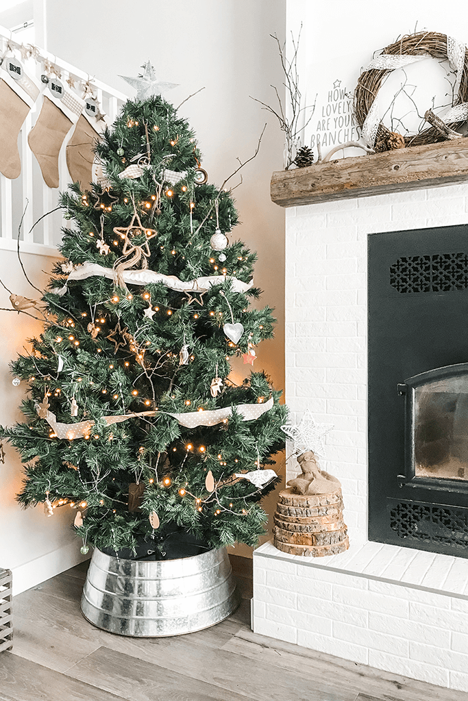 A living room decorated with a Christmas tree and rustic ornaments.