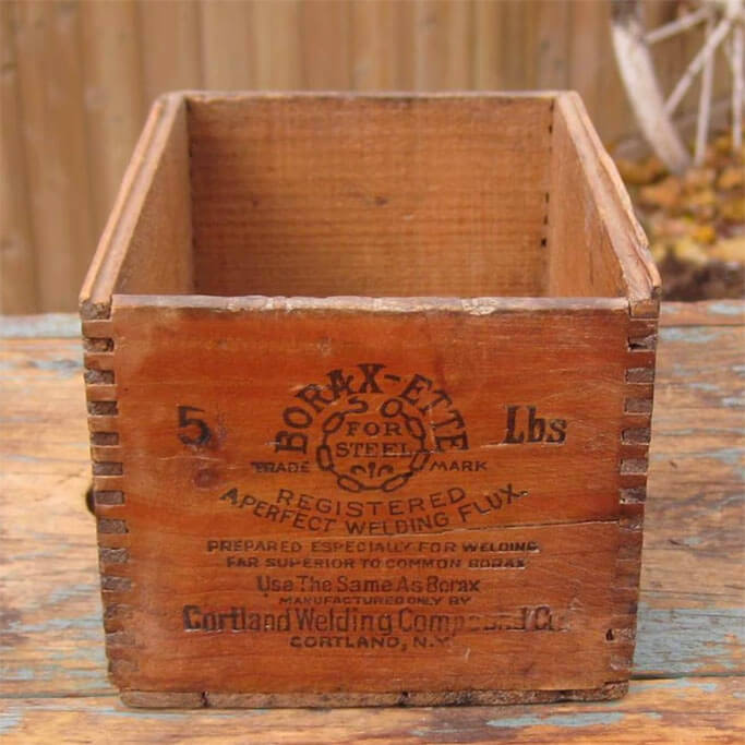Small wooden vintage crate with faded writing on the front.