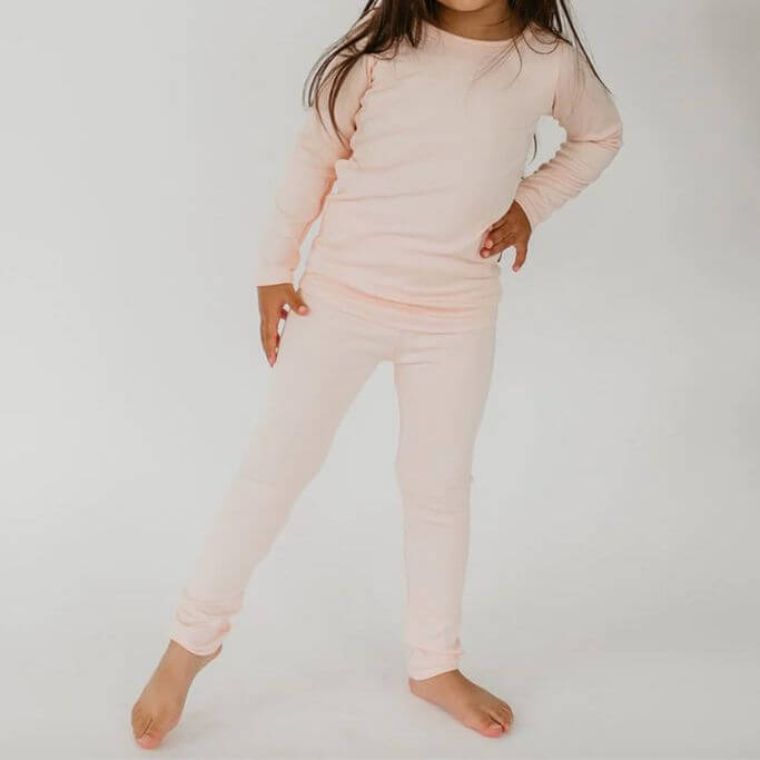 A child wearing a light pink pajama set.