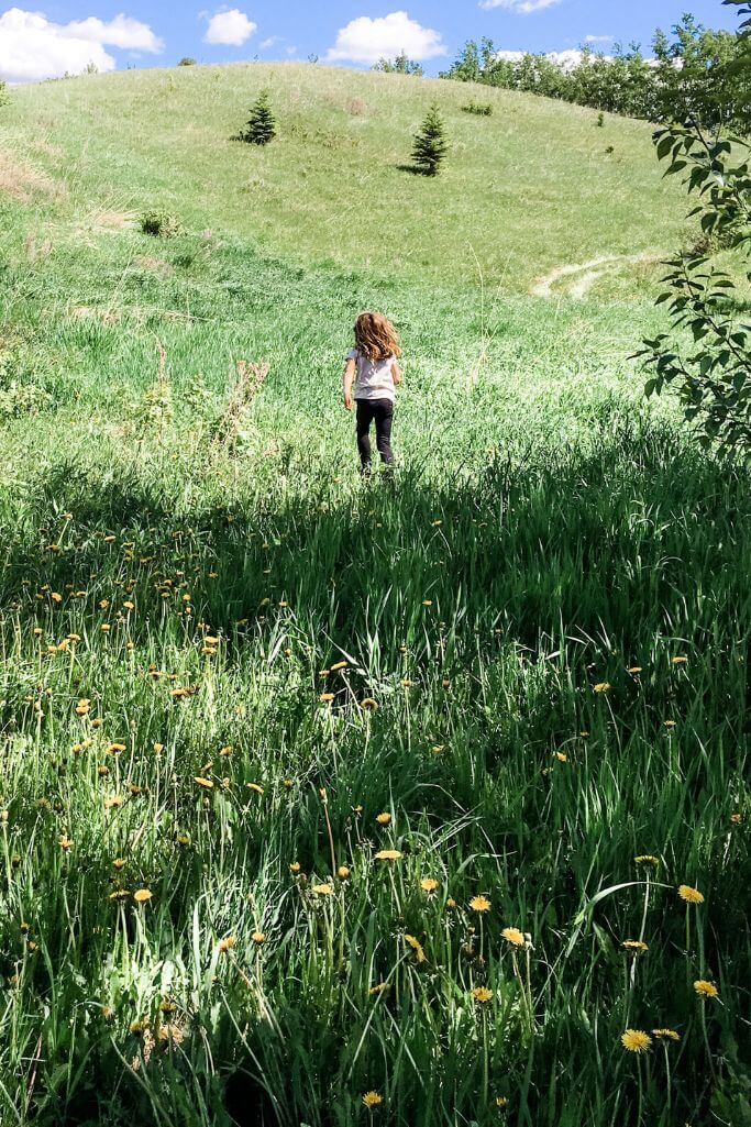 A little girl running through a field.