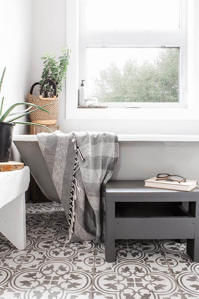 A bright bathroom with patterned grey and white tiles.