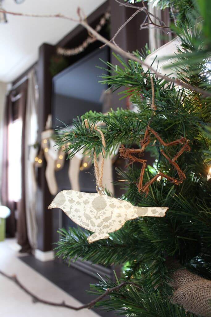 Closeup of a bird ornament hanging in a Christmas tree.