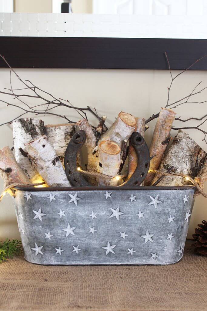 A metal basket filled with branches, burlap and a rusty horseshoe.