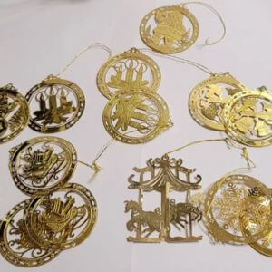 Vintage brass Christmas ornaments on a white background.