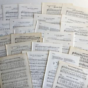 Multiple sheets of Christas music spread in a pile.