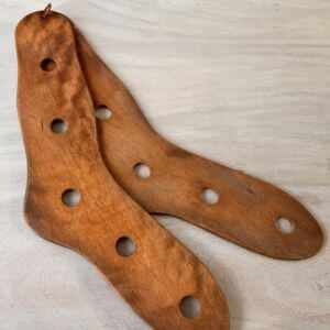 Wooden stocking stretchers on a grey background.