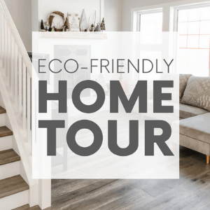 Living room with wood floors, a fireplace and a grey couch with the words "eco-friendly home tour." Click to visit post.