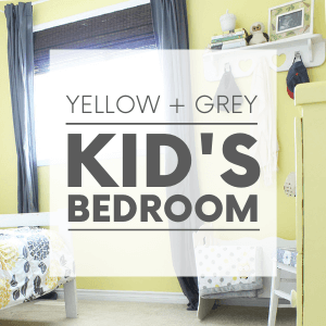A kid's bedroom with yellow walls, grey curtains and a floral bedspread with the words "yellow + grey kid's bedroom." Click to visit post.