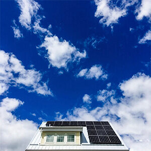 A roof with solar panels in front of a bright blue sky. Click to visit post.