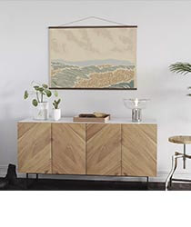 An abstract landscape print above a wooden credenza.