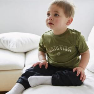 A little boy wearing a green tee with text earth first on it.