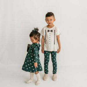 A little boy and girl wearing matching green patterned clothing.