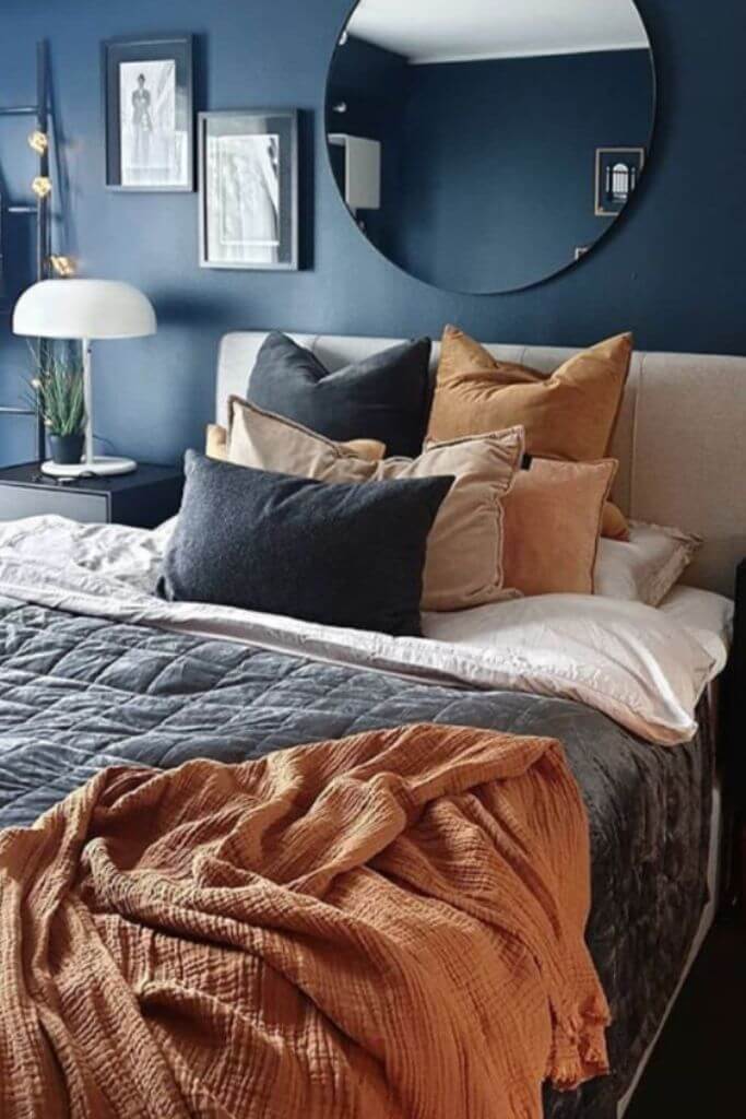 Bedroom with dark blue walls and orange-brown accents.