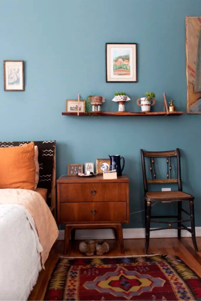Bedroom with light blue walls and orange accents.