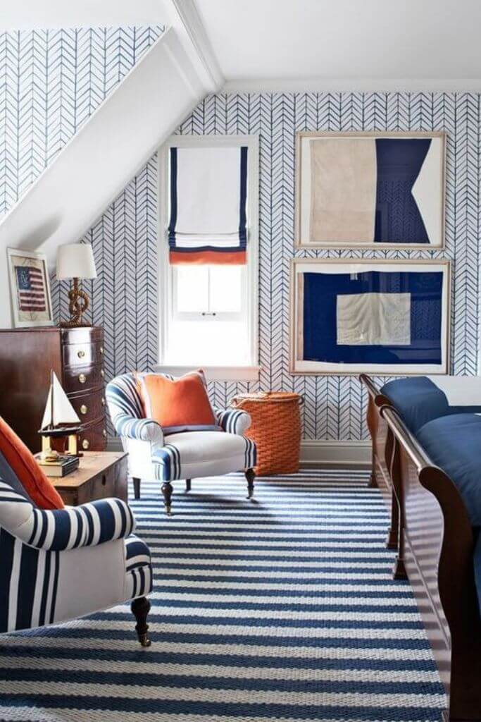 Bedroom with blue and white wallpaper and blue and orange accents.