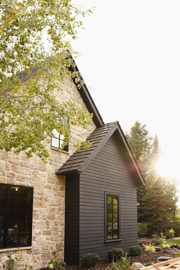 A home exterior with a mixture of stone siding and horizontal fiberglass siding.