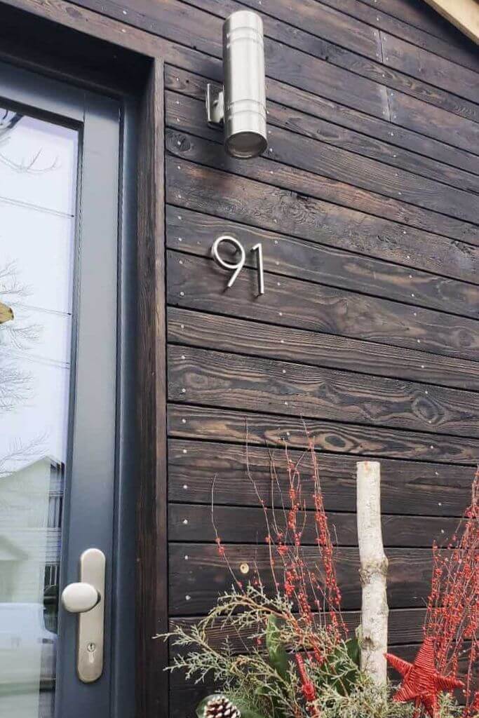 Closeup of a home with dark wooden siding.