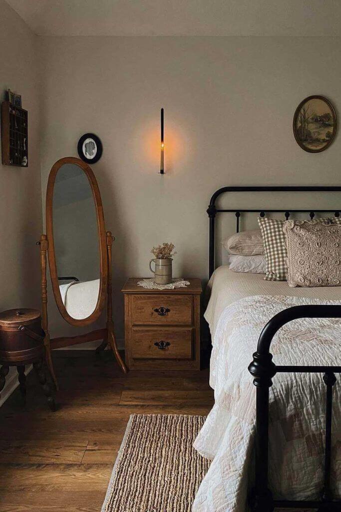 A vintage decorated bedroom with wooden furniture and off-white bedding.