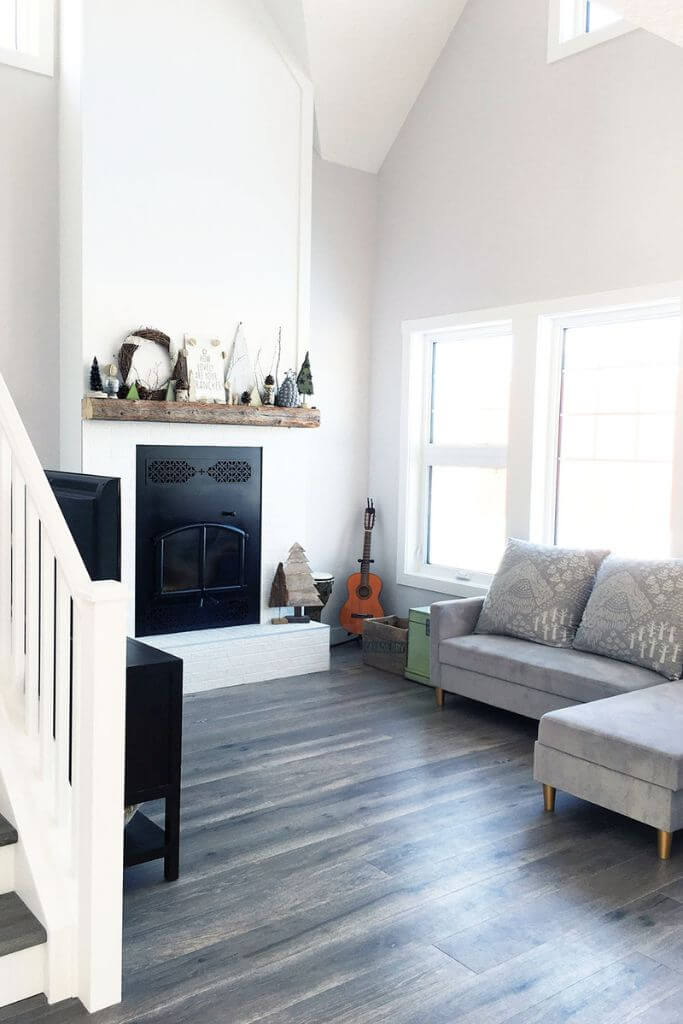 A living room with a black fireplace and a grey sofa.