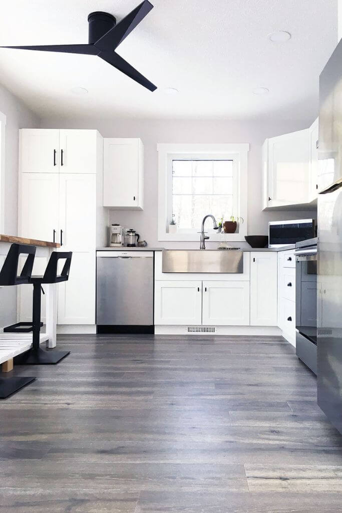 A bright white kitchen with stainless steel appliances.