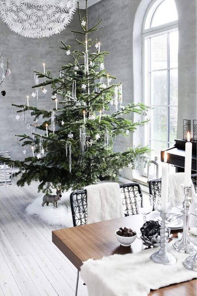 A dining area decorated for Christmas with shiny silver decor.