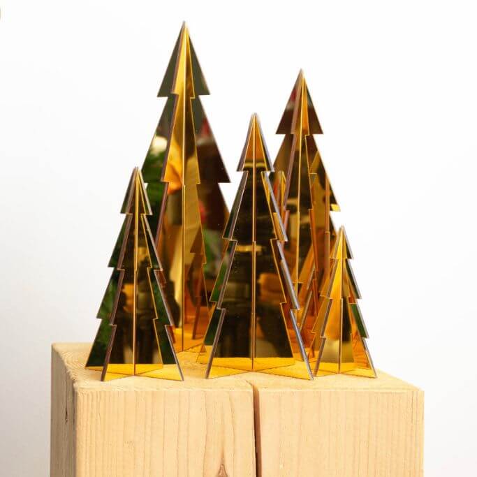 Five small gold Christmas trees in a variety of sizes.