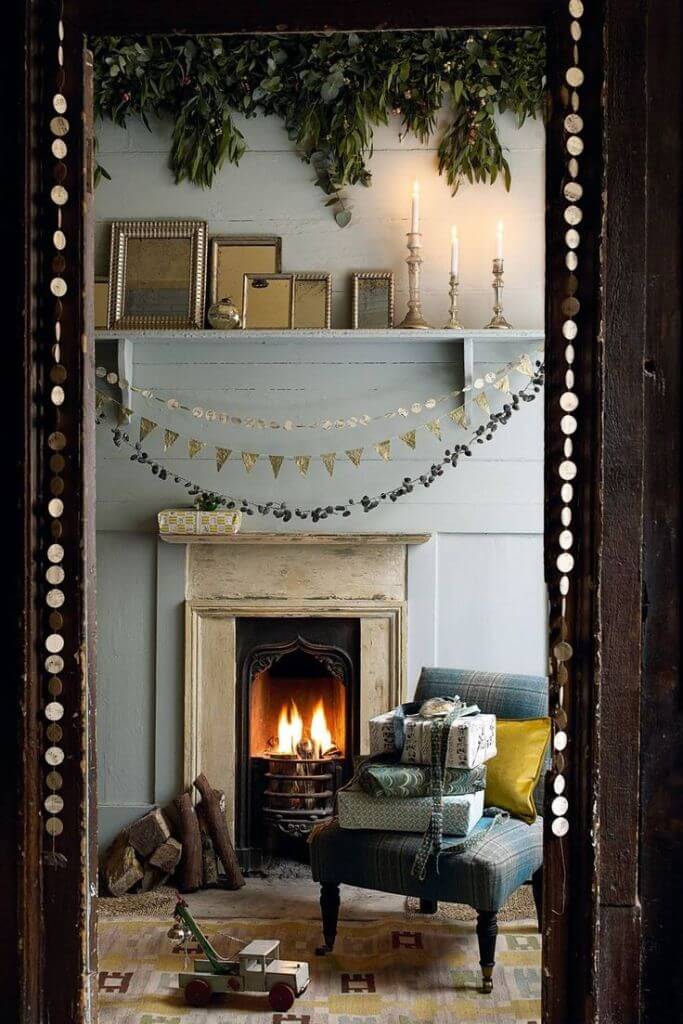 A fireplace mantel decorated for Christmas with various garlands.