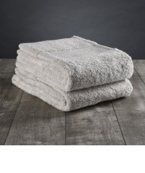A set of cream towels on a wooden floor.