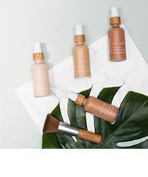 Different shades of foundation and a makeup brush on a background of white paper and a green leaf. Click to visit the Earth Hero website.