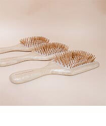 Three bamboo brushes on a neutral background.