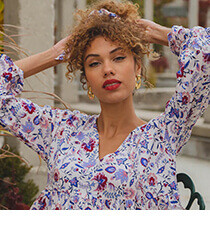 A young woman wearing a floral top and red lipstick. Click to visit Tamga website.