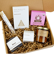 A gift box containing a candle, soap and other small items.