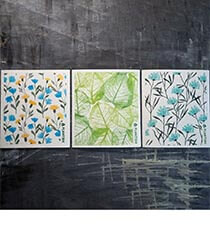 Three Swedish dishcloths on a grey background.