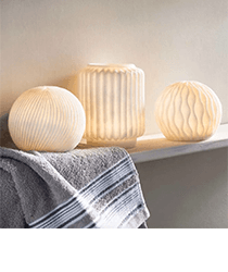 Three off-white candle holders sitting on a white shelf. Click to visit the Vivaterra website.