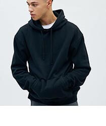 A young man wearing a black hooded sweater with his hands in his pockets. Click to visit KOTN website.