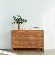 AVOCADO<br />
Bedroom Furniture A medium-toned wood dresser with a plant on top.