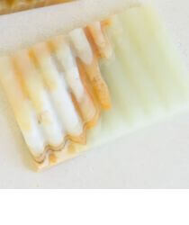 A soft green vintage soap dish on a white countertop.