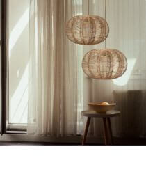 Two rattan pendant lights in a Scandinavian style interior.