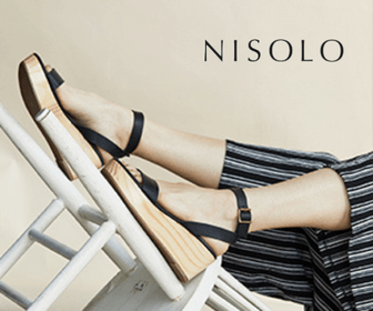 A pair of legs wearing striped pants and black sandals with the word "nisolo." Click to visit Nisolo's website.